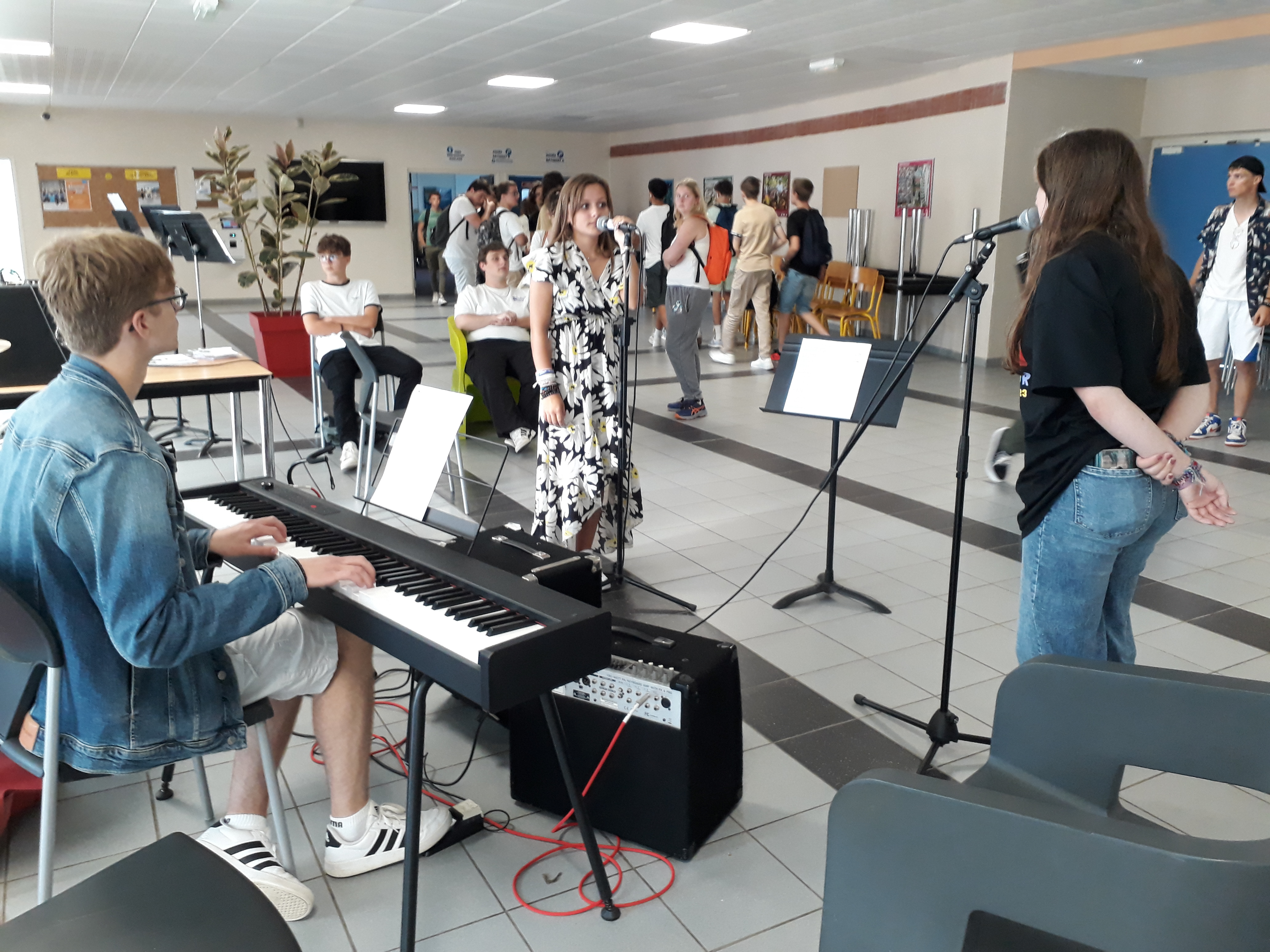 3 élèves de la section musique du lycée Robespierre à Arras se produisent au piano et au chant devant un public composé des anciens et nouveaux élèves de l'établissement