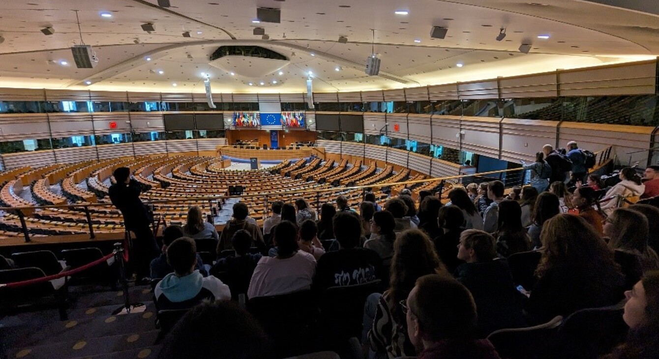 Des élèves sont assis dans l'hémicycle du parlement européen
