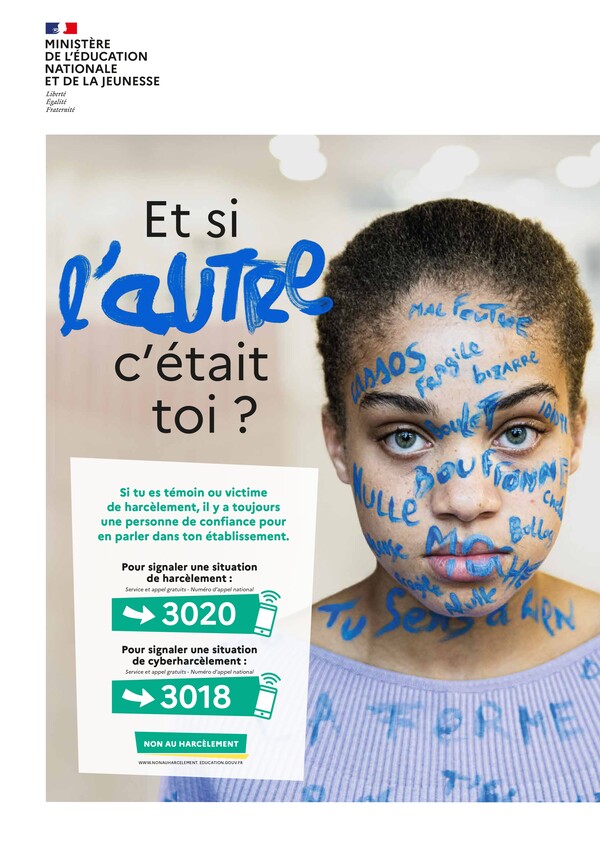 Affiche Non au harcèlement qui représente une élève avec des insultes écrites sur le visage à la peinture bleue, le titre est "Et si l'autre c'était toi ?" et les numéros d'alertes sont affichés