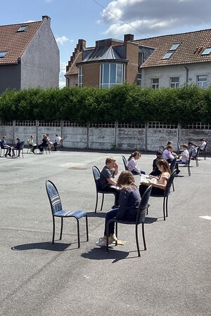 Des élèves sont face à face sur une chaise dans la cour de récréation