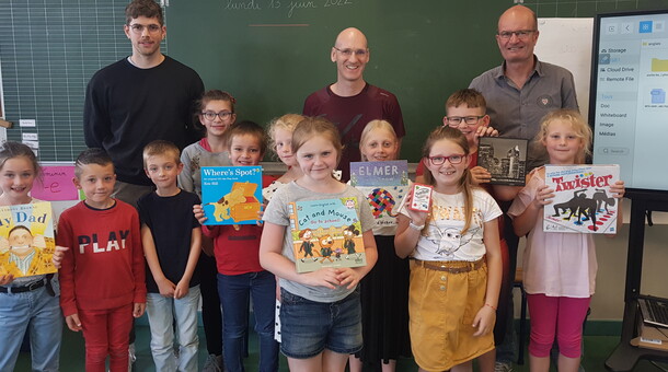 Les élèves de CE1 et CE2 de l'école Buisson à Béthune sont dans leur salle de classe et reçoivent des livres et des jeux dans le cadre de la remise de prix du concours ELVE EPS Numérique