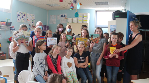 Les élèves de CM1 et CM2 de l'école La Fontaine à Saint-Floris sont dans leur salle de classe et reçoivent des livres et des jeux dans le cadre de la remise de prix du concours ELVE EPS Numérique