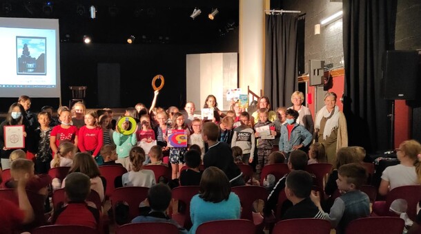 Les élèves de CM1 de l'école Prévert à Lillers sont dans une salle de spectacle et reçoivent des livres et des jeux dans le cadre de la remise de prix du concours ELVE EPS Numérique