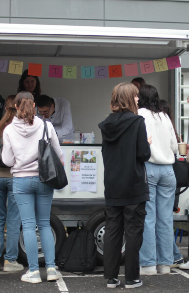 Des élèves sont dans un food truck et servent des élèves et personnels du lycée