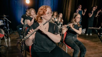 Les élèves de l'option musique du lycée Louis Blaringhem de Béthune sont sur une scène, au premier plan se trouvent 2 élèves qui jouent de la flûte à bec