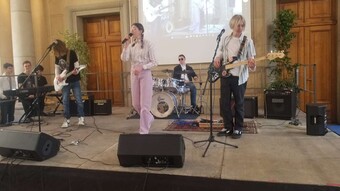4 collégiens jouent du rock sur une scène pour les élèves de leur collège