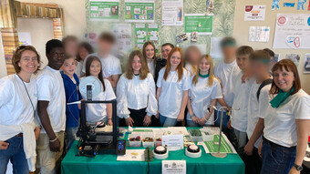 Les élèves entrepreneurs qui ont créé la mini-entreprise High School Protector se tiennent autour du stand qu'ils ont installé pour le festival des mini-entreprises