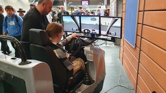 Une élève est dans un simulateur de conduite, accompagnée par un encadrant dans le cadre de l'animation sur la sécurité routière