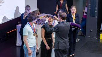 Une élève se voit remettre une médaille par le ministre de l'éducation nationale