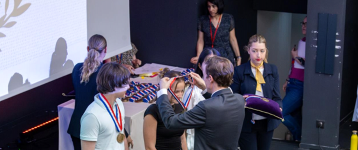 Une élève se voit remettre une médaille par le ministre de l'éducation nationale